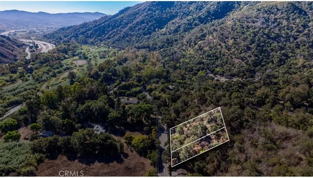a view of a house with a lush green forest