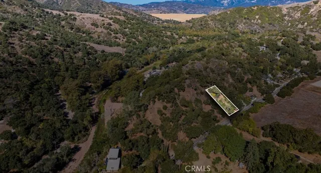 an aerial view of a brick house with a yard and mountain view
