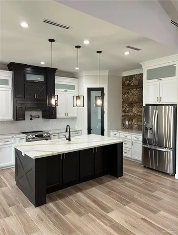 a kitchen with stainless steel appliances granite countertop a sink stove and refrigerator