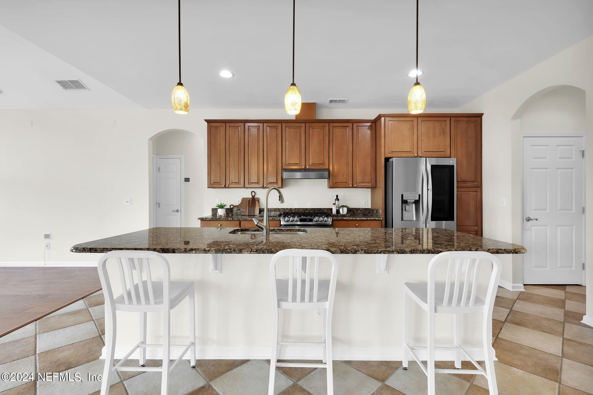 2044 River's Own Road St. Augustine, FL 32092 - Photo 5 of 48 a kitchen with stainless steel appliances kitchen island granite countertop a refrigerator a stove a sink a dining table and chairs with wooden floor