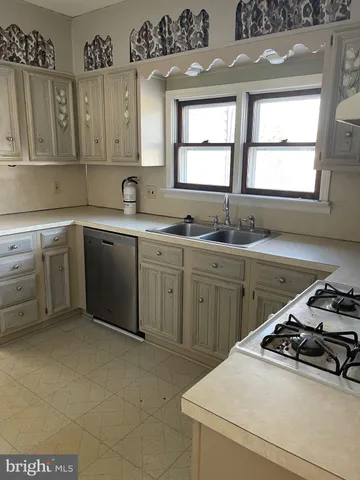 a kitchen with a sink stove and cabinets