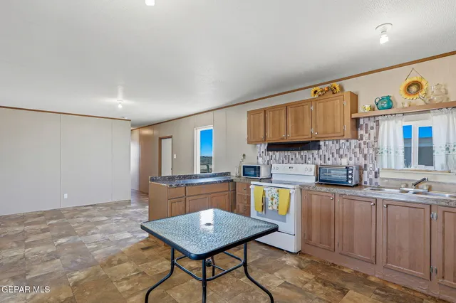 a kitchen with stainless steel appliances granite countertop a sink stove and cabinets