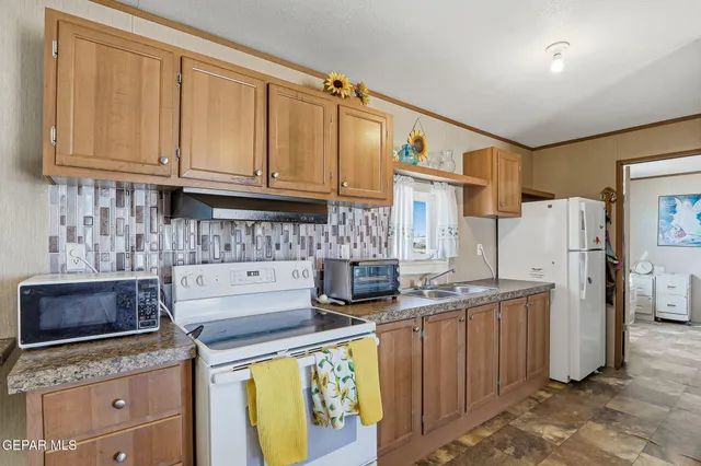 a kitchen with stainless steel appliances granite countertop a stove a refrigerator a sink a stove a dining table and chairs with wooden floor