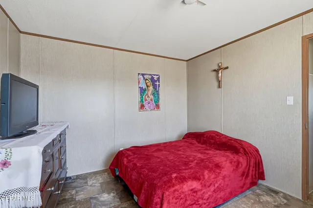 a bedroom with a bed dresser and a flat screen tv