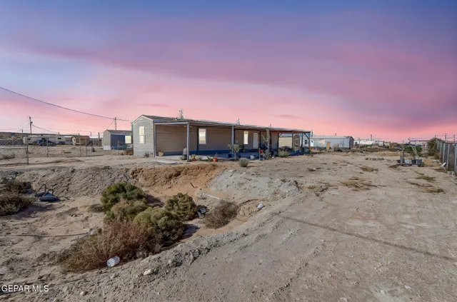 a view of a dry yard with wooden fence