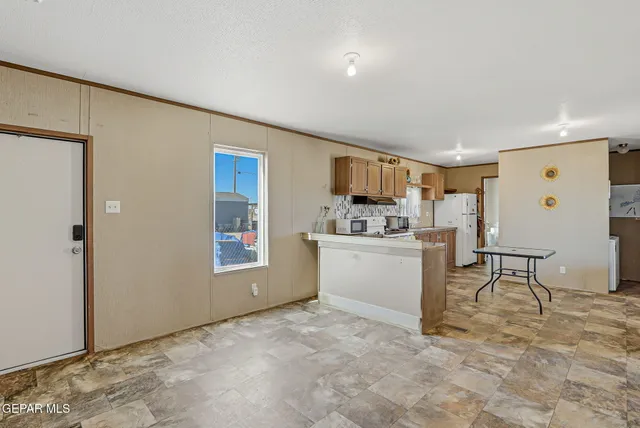 a view of kitchen with refrigerator and window