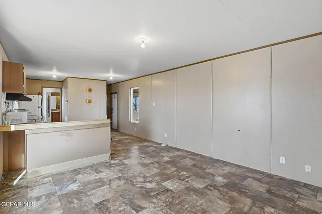 a view of a kitchen with refrigerator and white cabinets