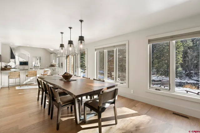 a view of a a dining room with furniture window and wooden floor