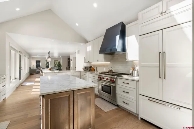 a kitchen with stainless steel appliances granite countertop a stove a refrigerator and a sink