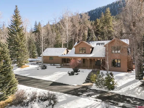 a view of a house with a yard covered in snow