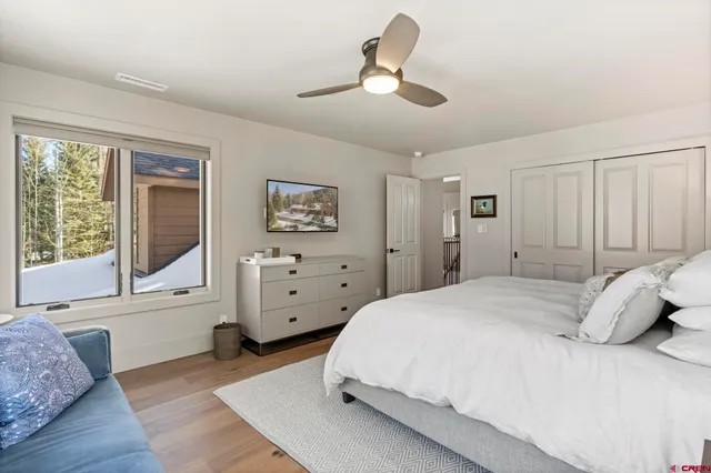a spacious bedroom with a bed and wooden floor