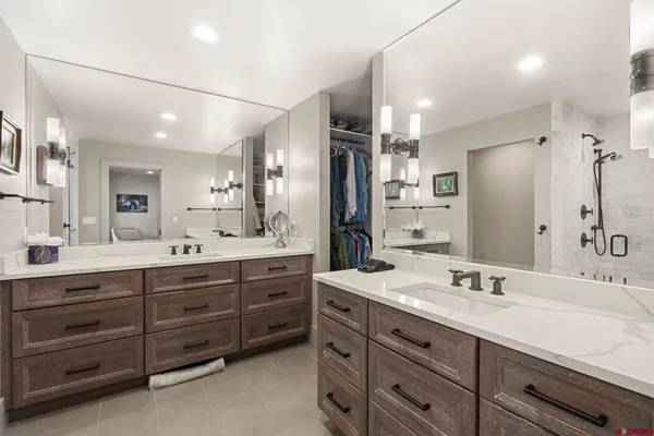 a bathroom with a granite countertop sink double vanity and a large mirror