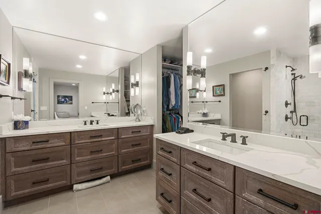 a bathroom with a granite countertop sink double vanity and a large mirror