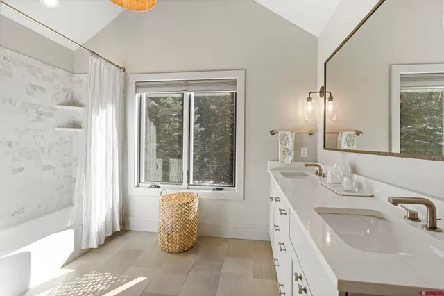 a bathroom with a tub sink and mirror