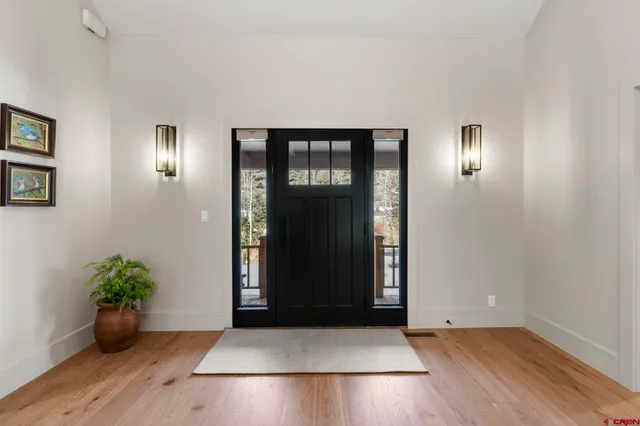 an empty room with wooden floor and hallway