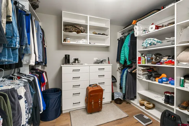 a view of walk in closet with clothes and shoes