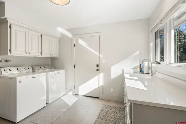 a kitchen with a sink a stove cabinets and a window