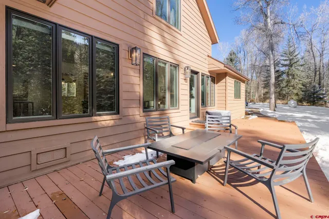 a view of a patio with table and chairs and floor to ceiling window