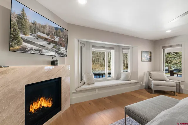 a living room with furniture a fireplace and a large window
