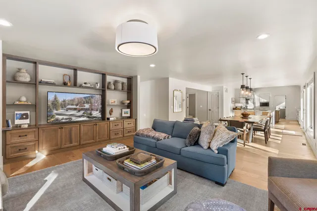 a living room with furniture and a wall painting