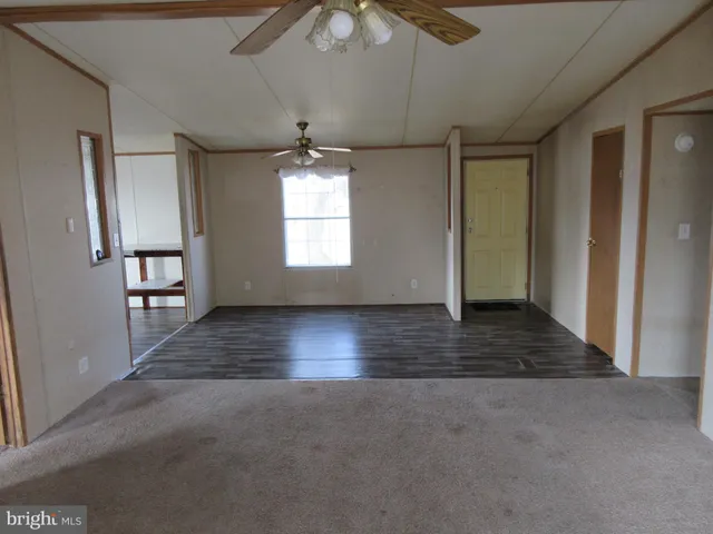 an empty room with windows and ceiling fan