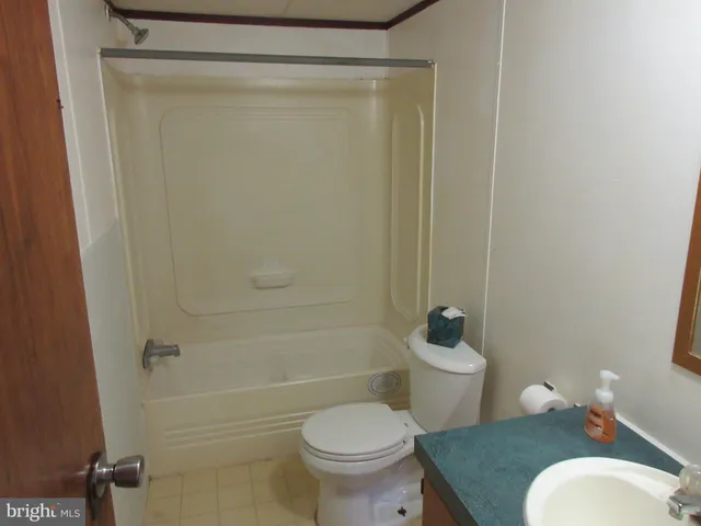a white toilet sitting next to a bathroom sink and vanity