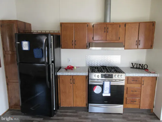 a kitchen with stainless steel appliances granite countertop a refrigerator and a stove