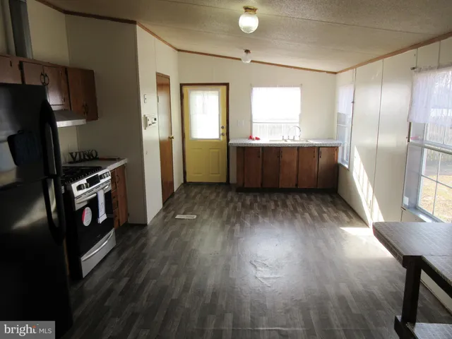 a kitchen with stainless steel appliances wooden floors and wooden cabinets