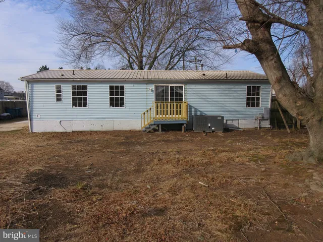 a view of a house with backyard and a tree