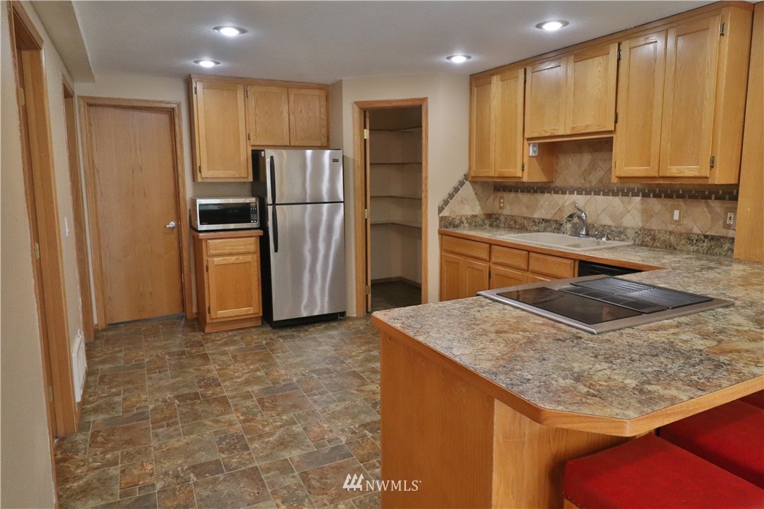 51 Quail Run Road Stevenson, WA 98648 - Photo 2 of 31 a kitchen with stainless steel appliances granite countertop a refrigerator a stove and a sink with wooden cabinets