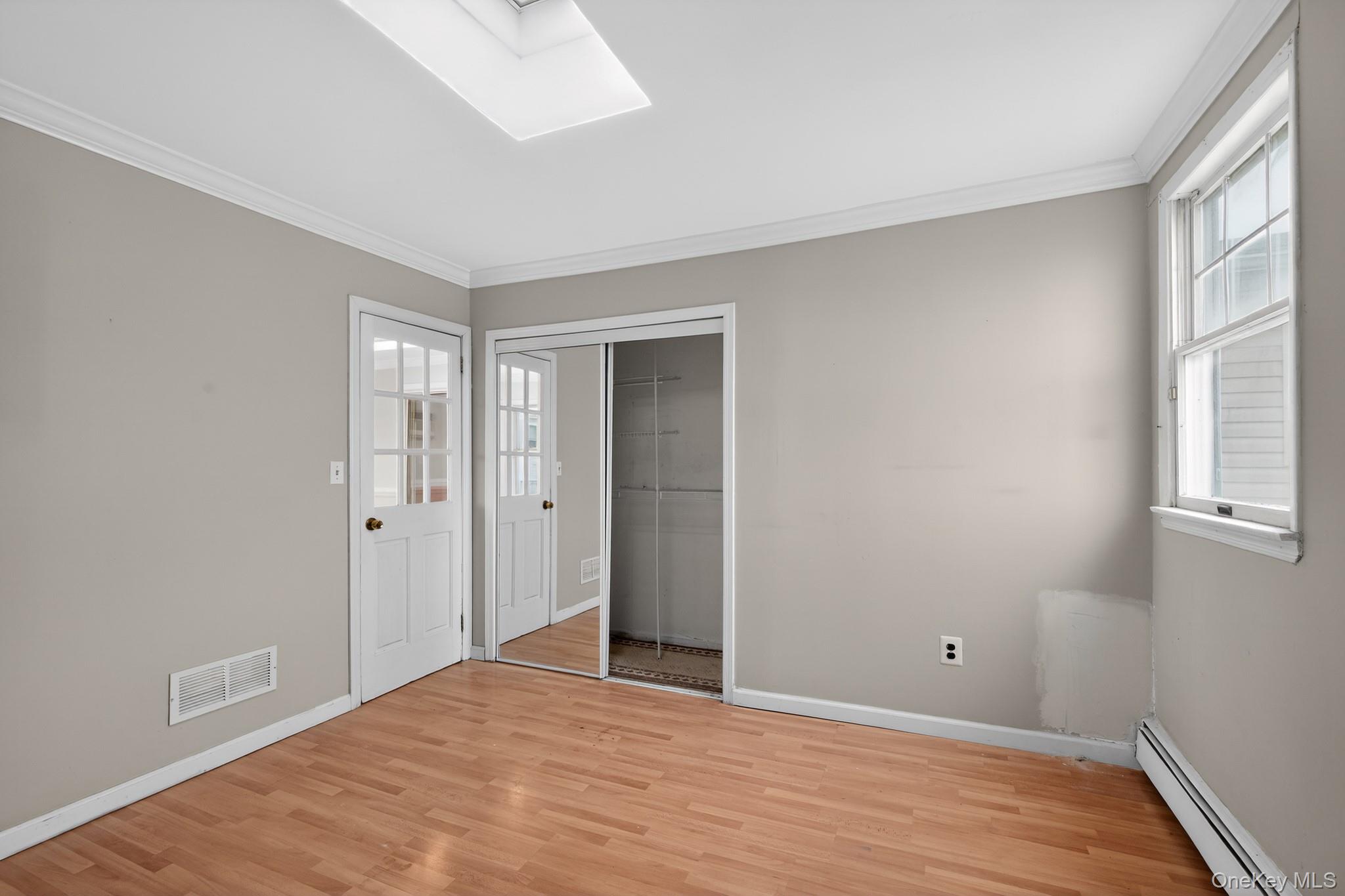 138 Spring Street Massapequa, NY 11758 - Photo 27 of 45 a view of an empty room with wooden floor and a window
