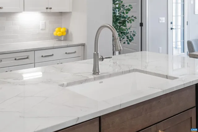 a kitchen with a stove a refrigerator a sink and chairs