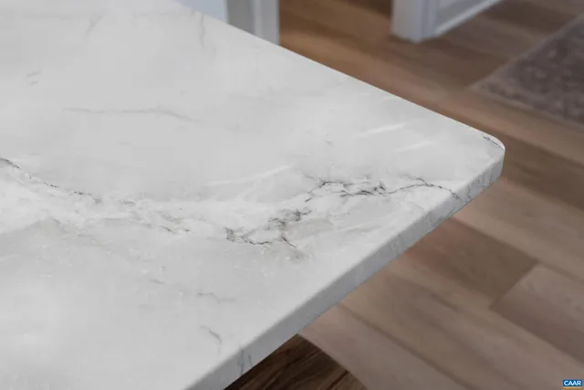 a kitchen with refrigerator and wooden floor