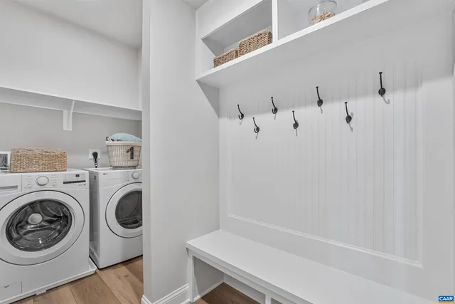 a kitchen with stainless steel appliances kitchen island granite countertop a refrigerator a sink dishwasher a stove and white cabinets with wooden floor