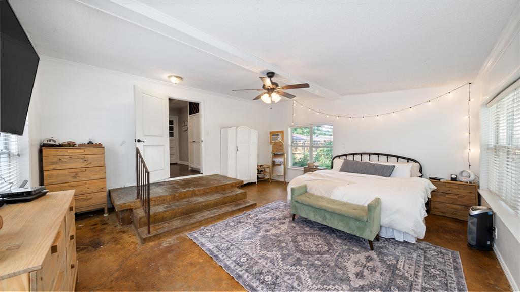 518 West Kansas Street Van, TX 75790 - Photo 14 of 24 a spacious bedroom with a bed a dresser and wooden floor