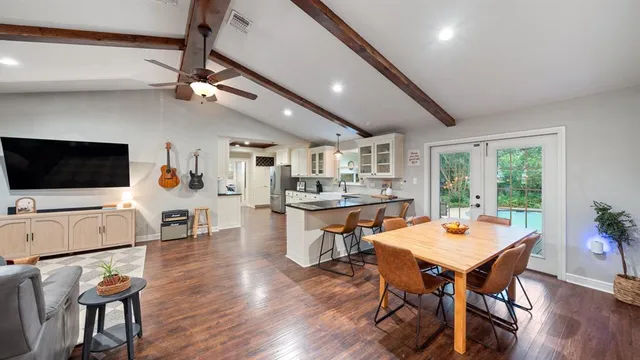 a open kitchen with stainless steel appliances kitchen island granite countertop a table chairs sink and cabinets