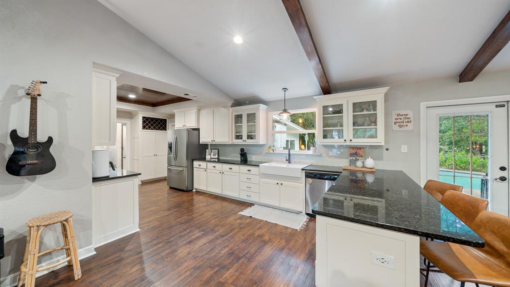 518 West Kansas Street Van, TX 75790 - Photo 7 of 24 a kitchen with stainless steel appliances kitchen island granite countertop a stove a sink a refrigerator and white cabinets with wooden floor