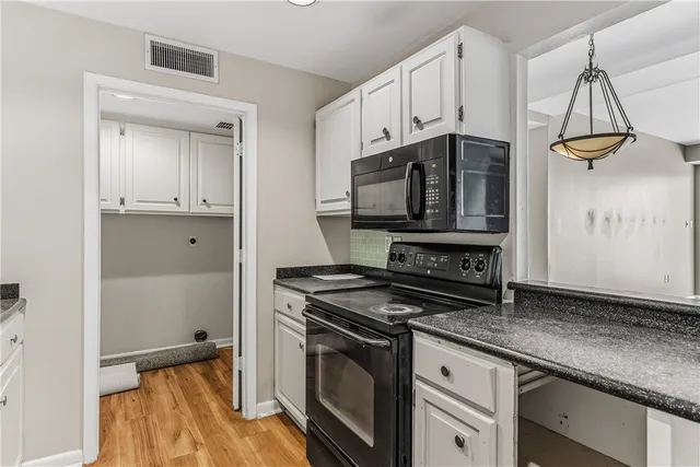 a kitchen with granite countertop a sink and cabinets