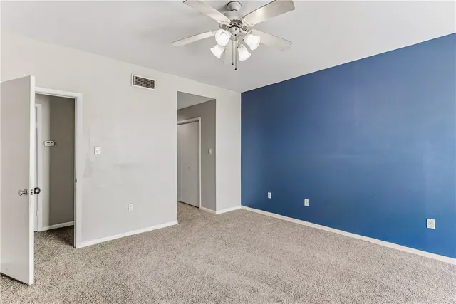 a view of an empty room with a ceiling fan
