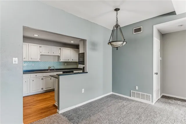 a kitchen with granite countertop a sink a stove and cabinets
