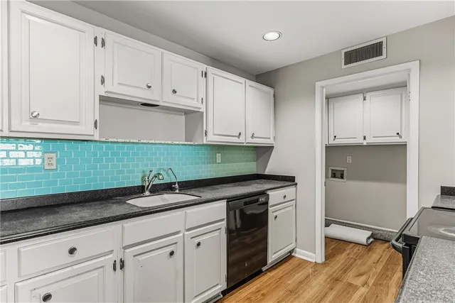 a kitchen with white cabinets and appliances