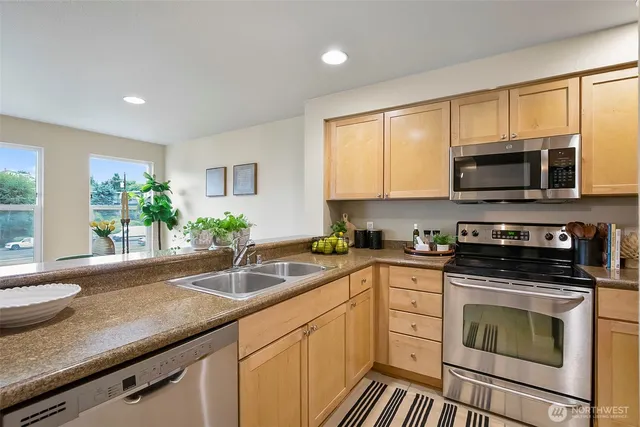 a kitchen with granite countertop cabinets stainless steel appliances and a window