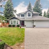 a front view of a house with a garden and yard
