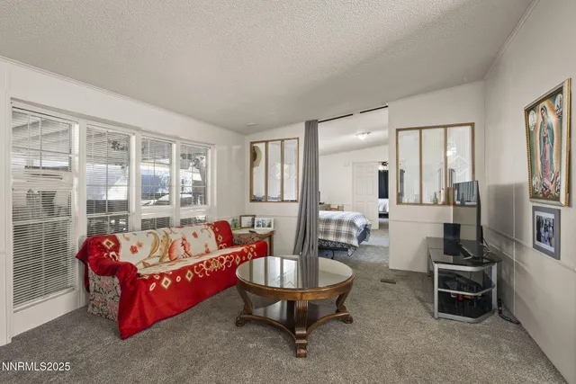 a living room with furniture a flat screen tv and a large window