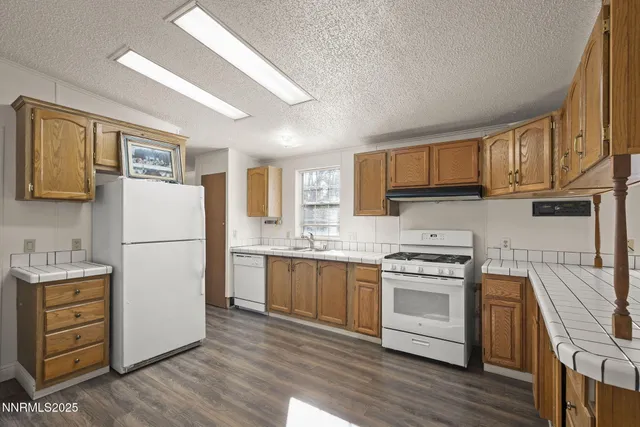 a kitchen with a refrigerator stove and wooden cabinets