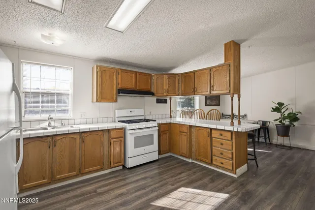 a kitchen with stainless steel appliances granite countertop a stove a sink dishwasher and a refrigerator
