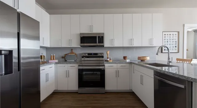 a kitchen with cabinets stainless steel appliances a sink and a counter space