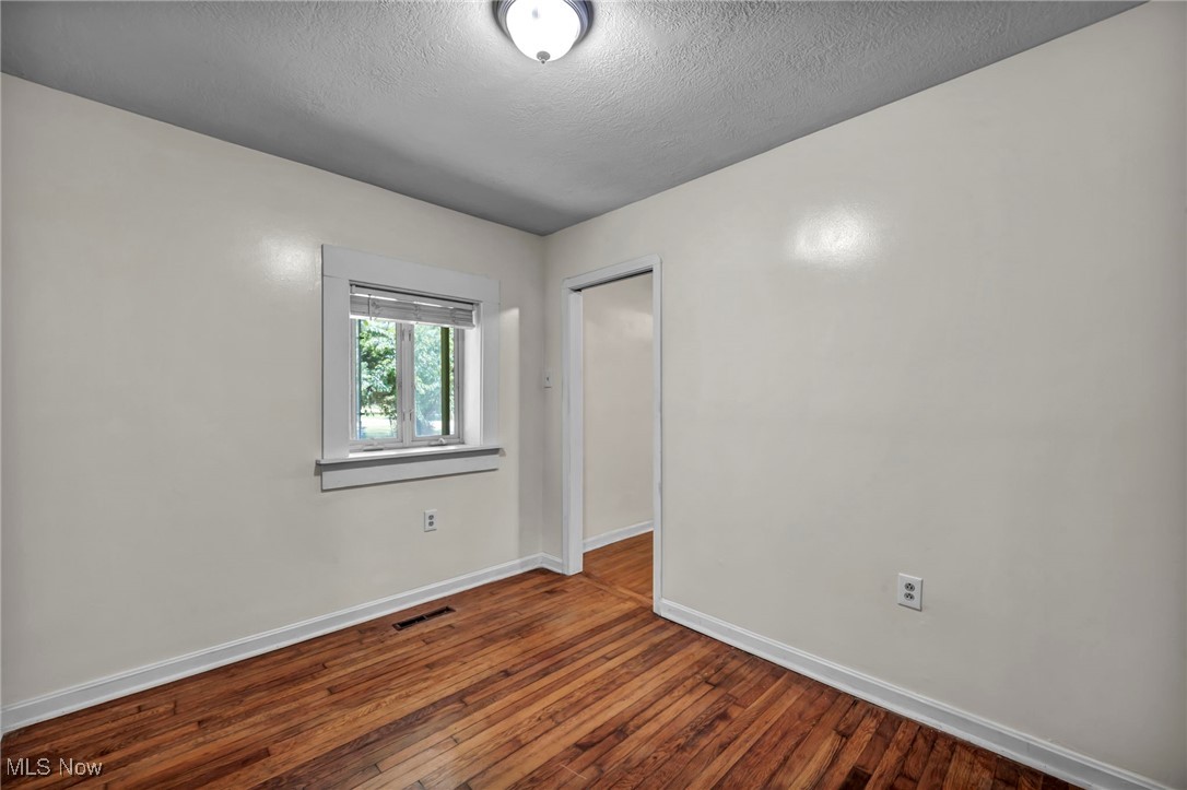 10982 Root Road Columbia Station, OH 44028 - Photo 13 of 49 Empty room with dark wood-type flooring and a textured ceiling