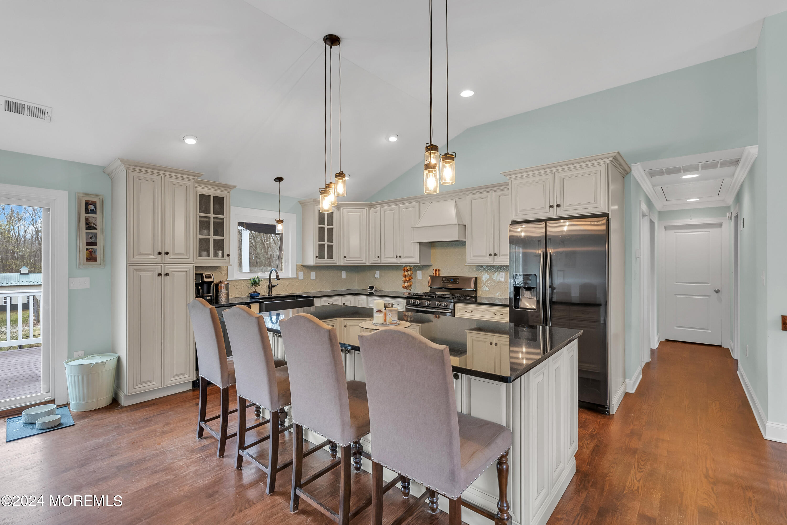877 Hyson Road Jackson, NJ 08527 - Photo 5 of 35 a kitchen with stainless steel appliances kitchen island granite countertop a refrigerator a stove a sink a dining table and chairs with wooden floor