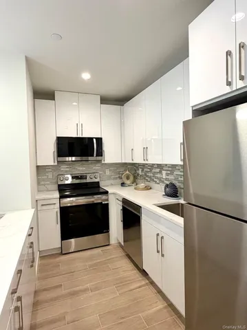 a kitchen with stainless steel appliances white cabinets and a refrigerator